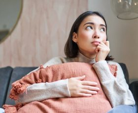 woman looking pensive and deep in thinking while sitting in the living room